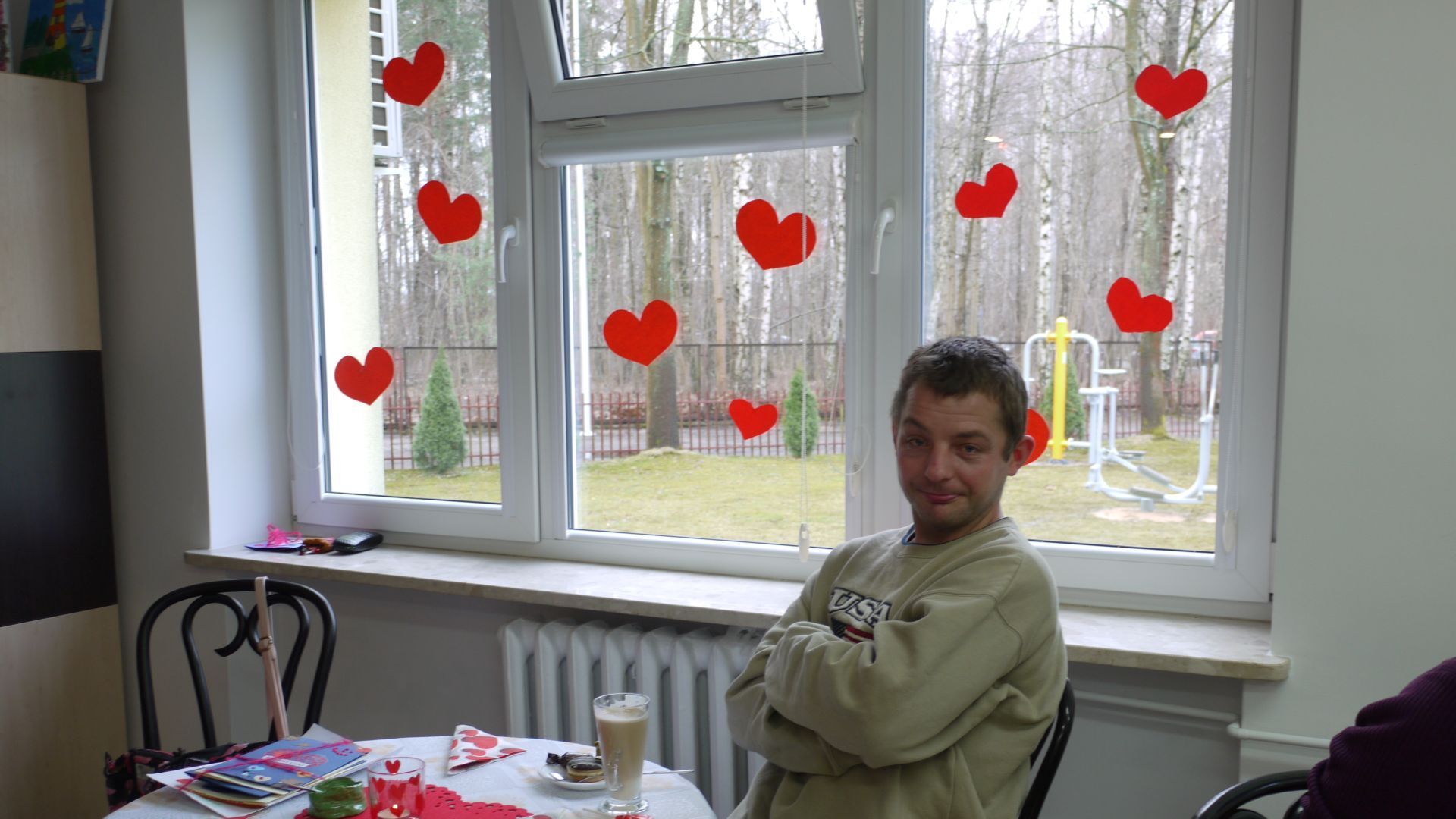 Rafał T. siedzi przy stoliku z kawą w art.-kawiarni.