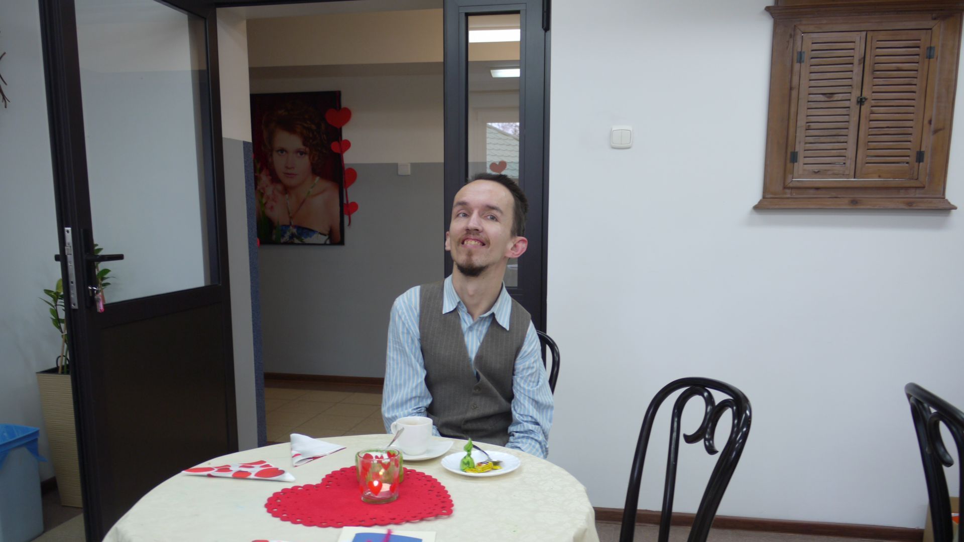 Rafał P. siedzący przy stoliku z kawą w art.-kawiarni.