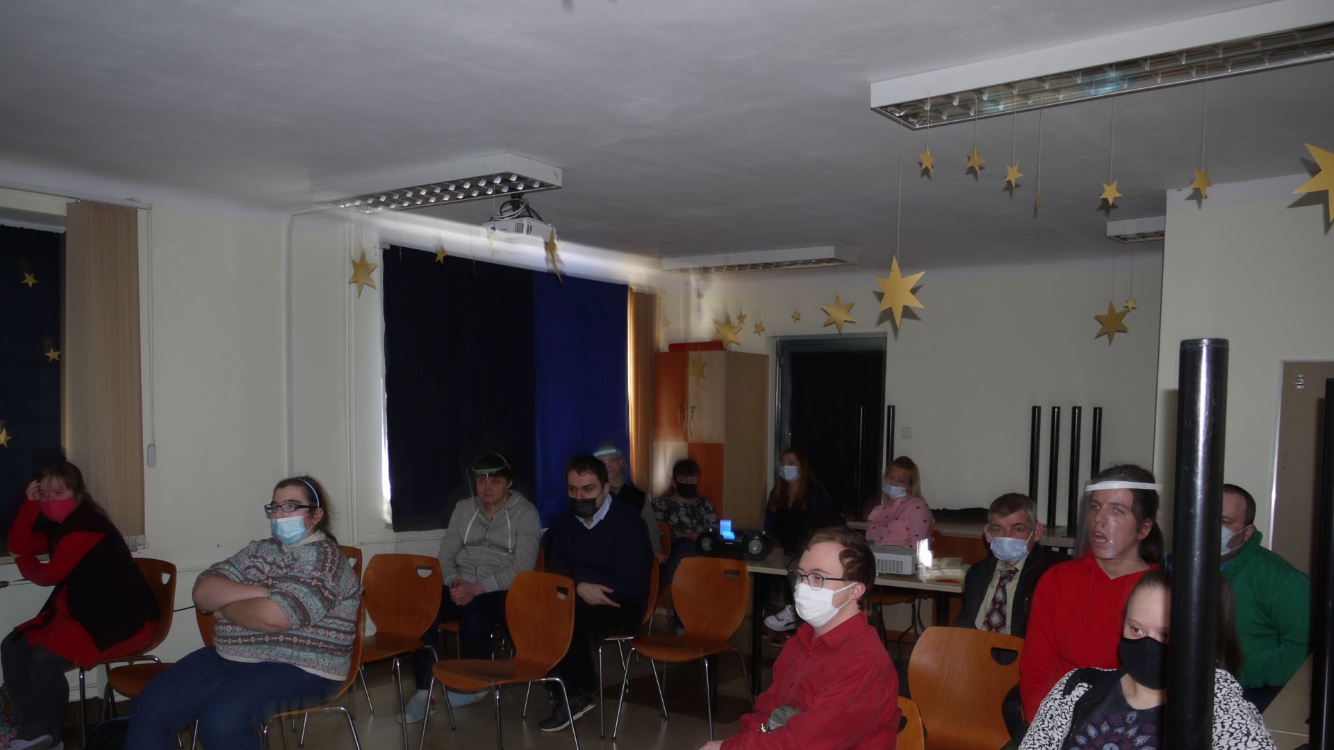 Uczestnicy oglądający film na sali klubowej.