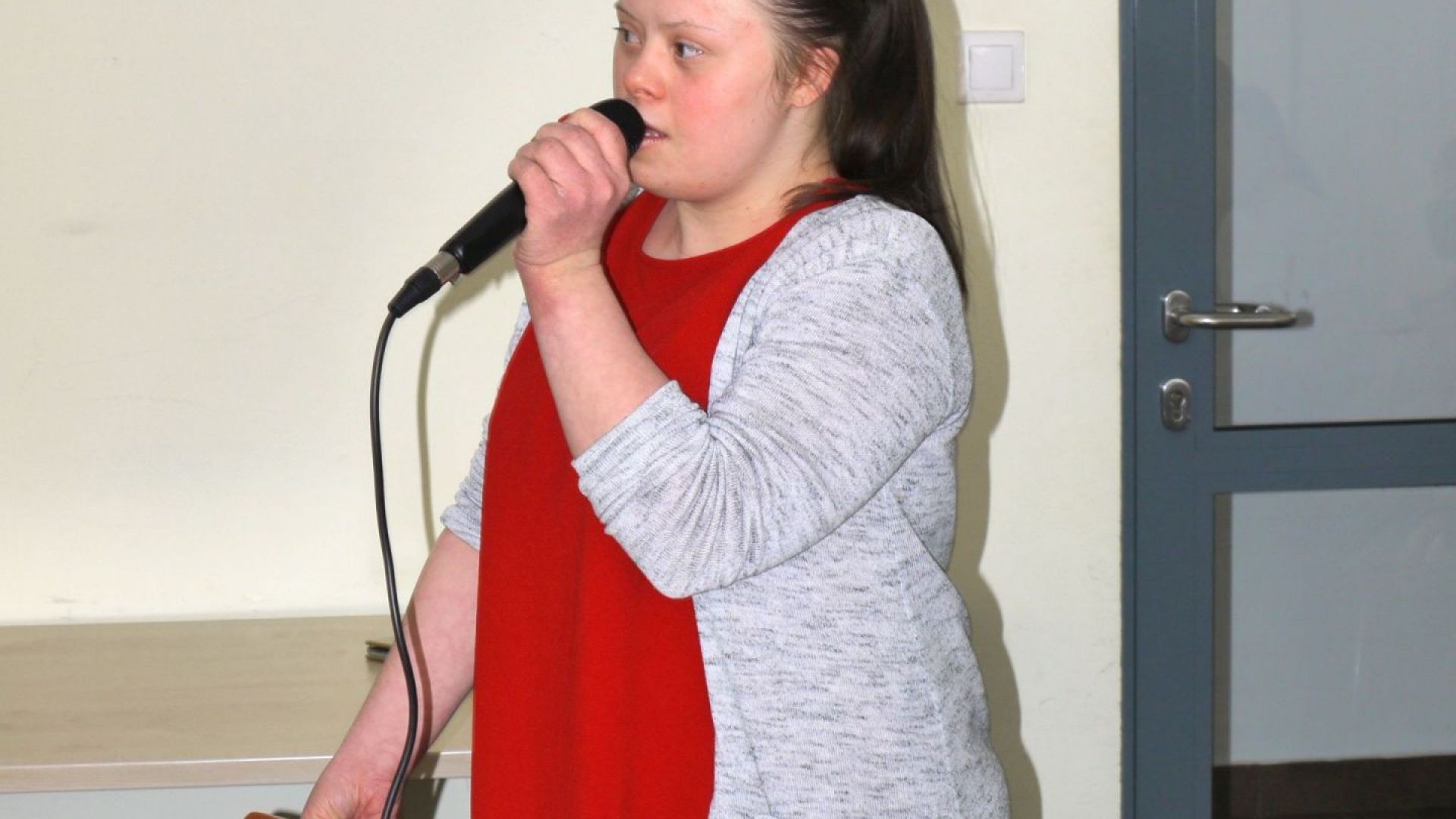 Marta Cz. śpiewająca do mikrofonu podczas karaoke.