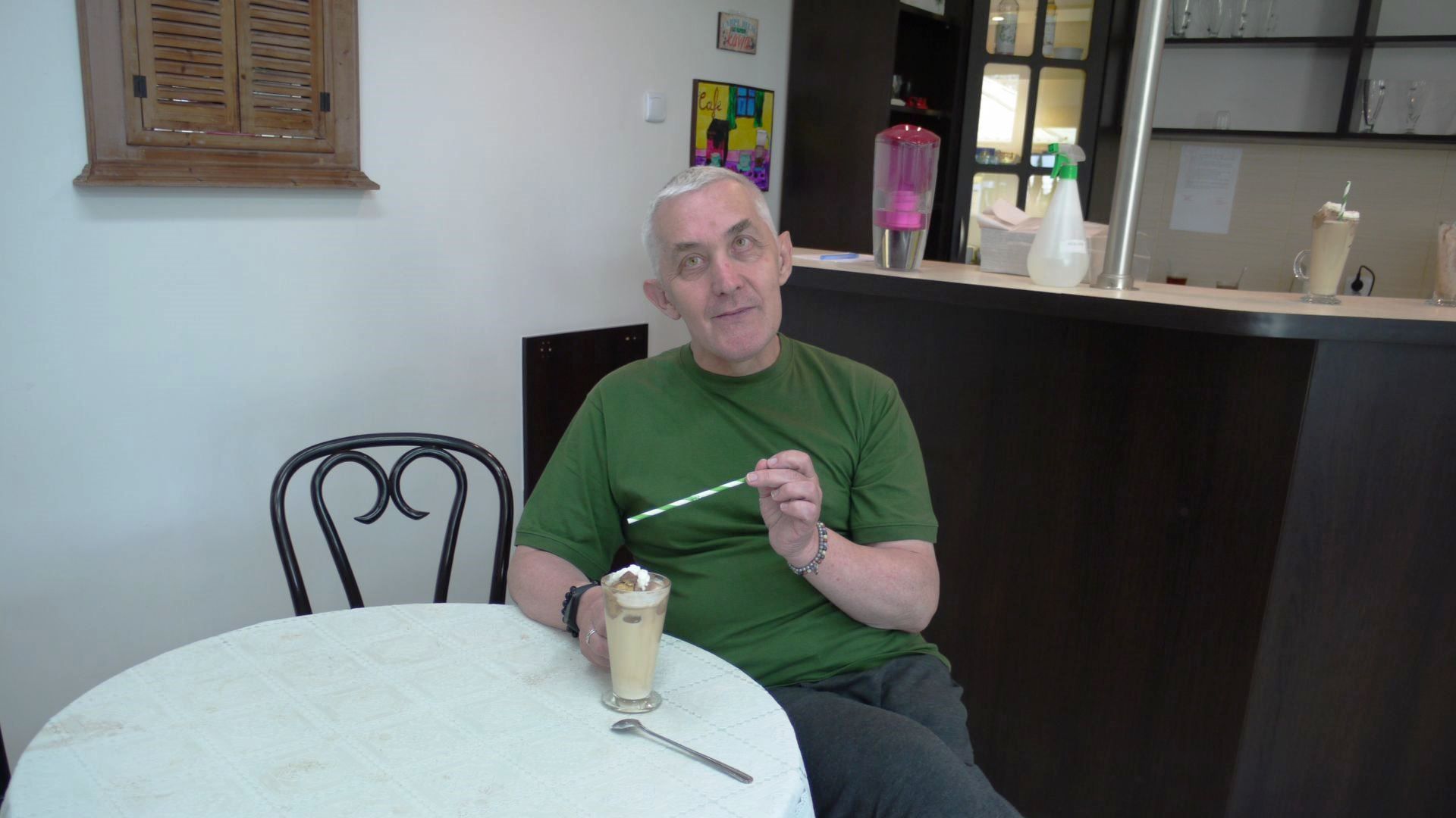 Tadeusz A. pijący kawę przy stoliku.