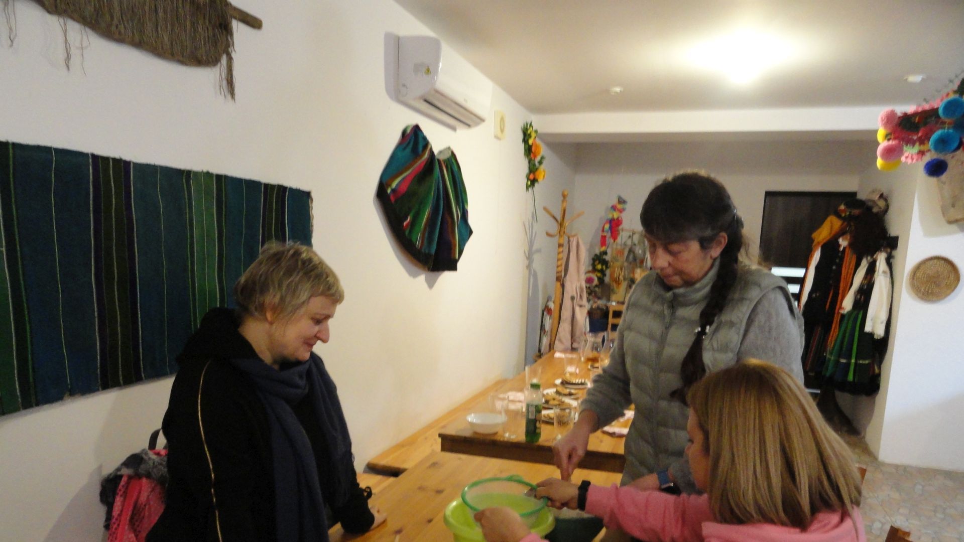 Pani Justyna Juszczak, pani Katarzyna Gronek i pani Małgorzata Pieńkos przesiewające mąkę.
