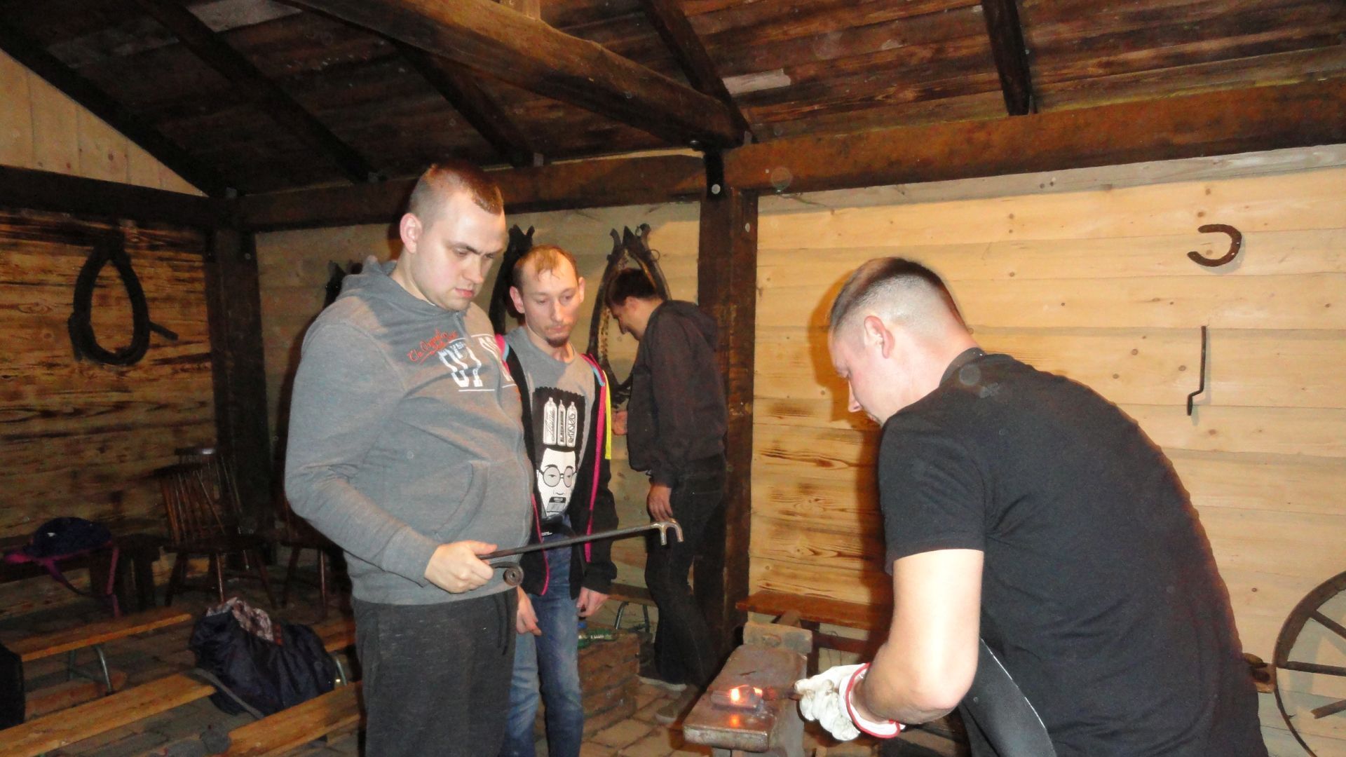 Paweł K. wraz z instruktorem, podczas wykonywania podkowy na warsztatach kowalstwa artystycznego.
