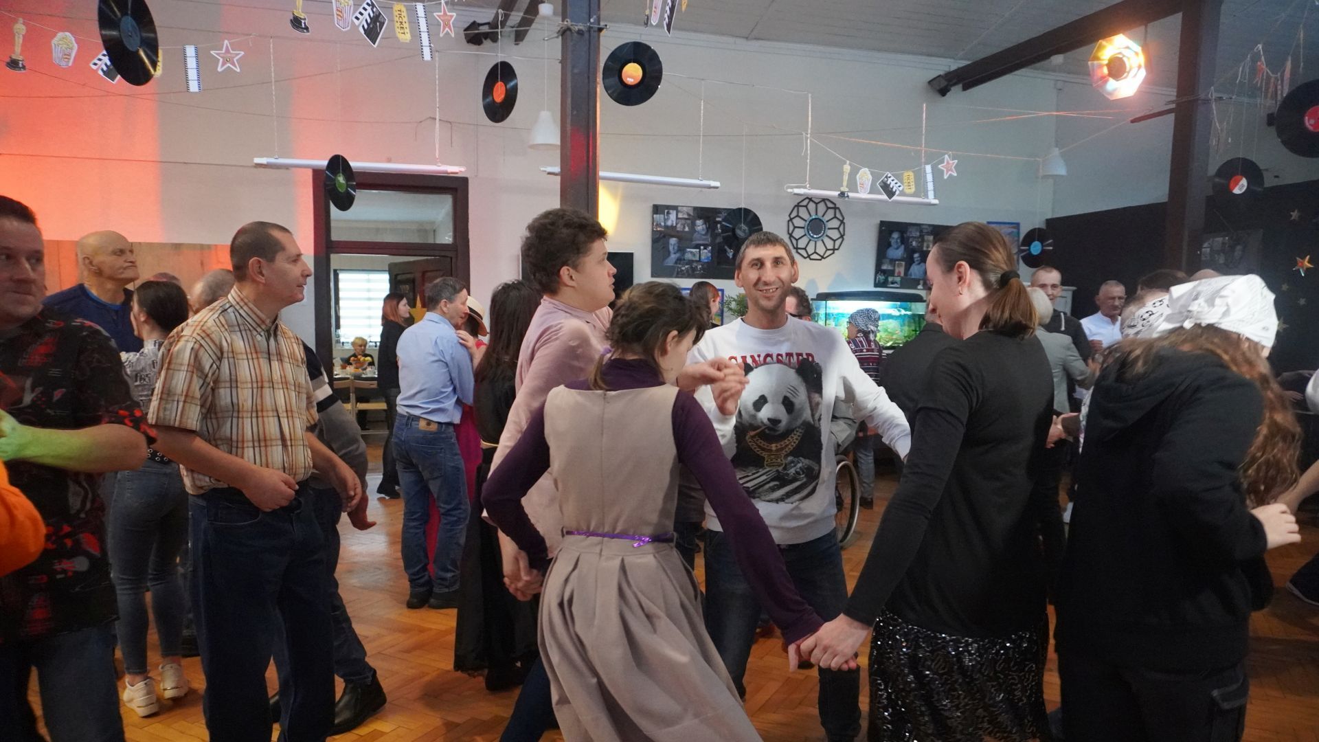 Uczestnicy tańczą w kółku podczas zabawy andrzejkowej w DPS ''Jedlina'' w Mieni.