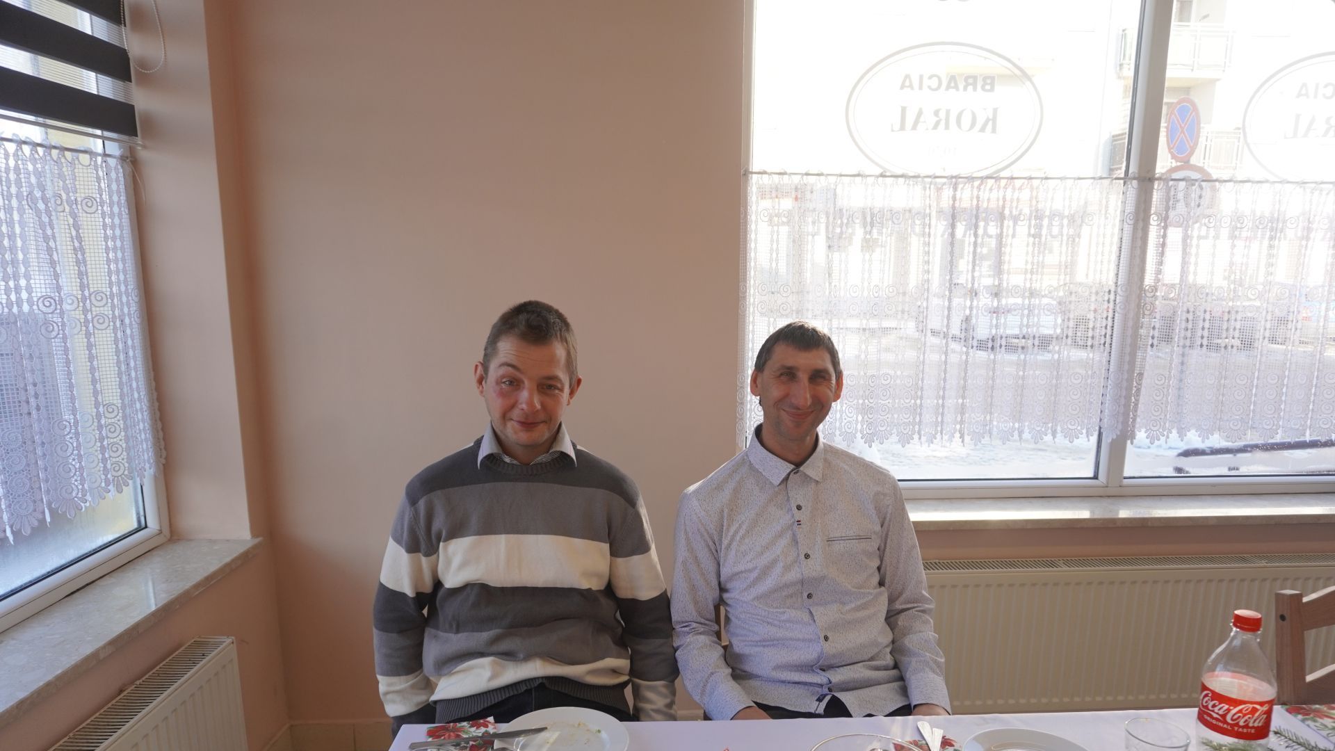 Uczestnicy Rafał T. i Sebastian C. pozują do zdjęcia przy świątecznym stole. 
