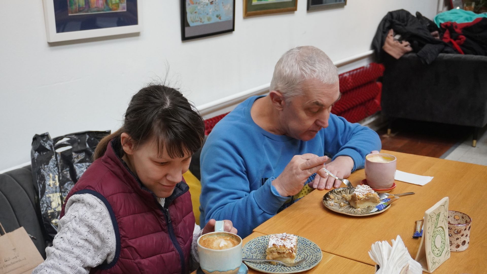 Małgosia i Tadeusz jedzą szarlotkę i piją kawę w kawiarni toMy. 