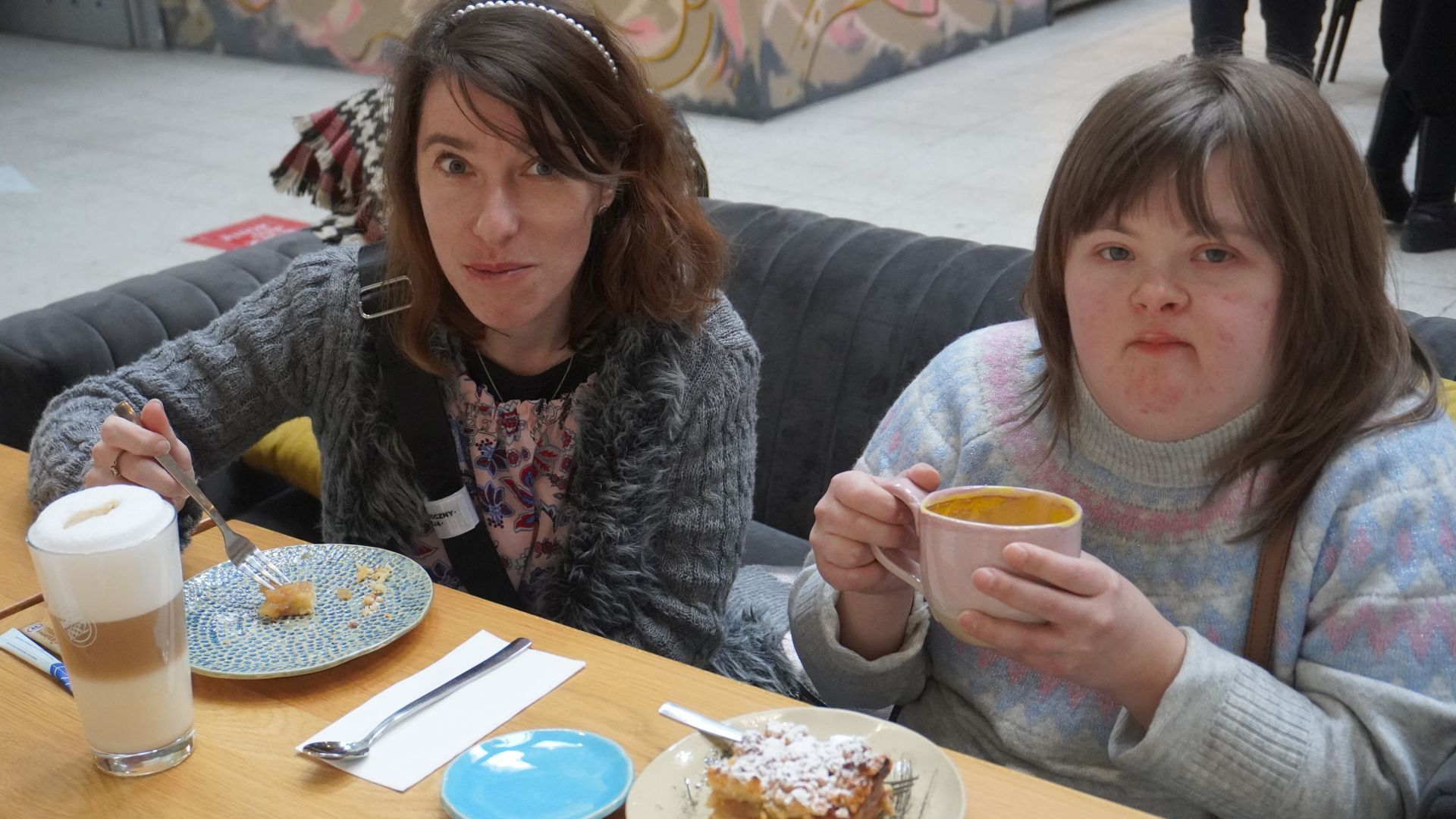 Uczestniczki Justyna i Sylwia piją kawę i jedzą szarlotkę w kawiarni toMy. 