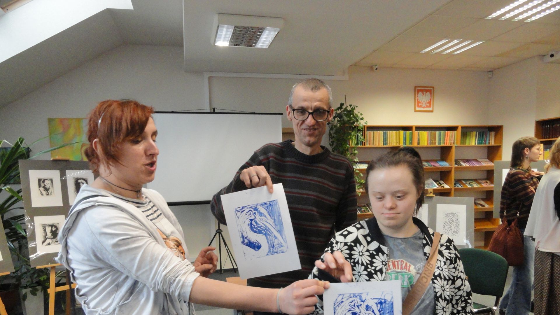 Uczestnicy prezentują swoje prace wykonane podczas wernisażu w Bibliotece Pedagogicznej w Mińsku Mazowieckim.  