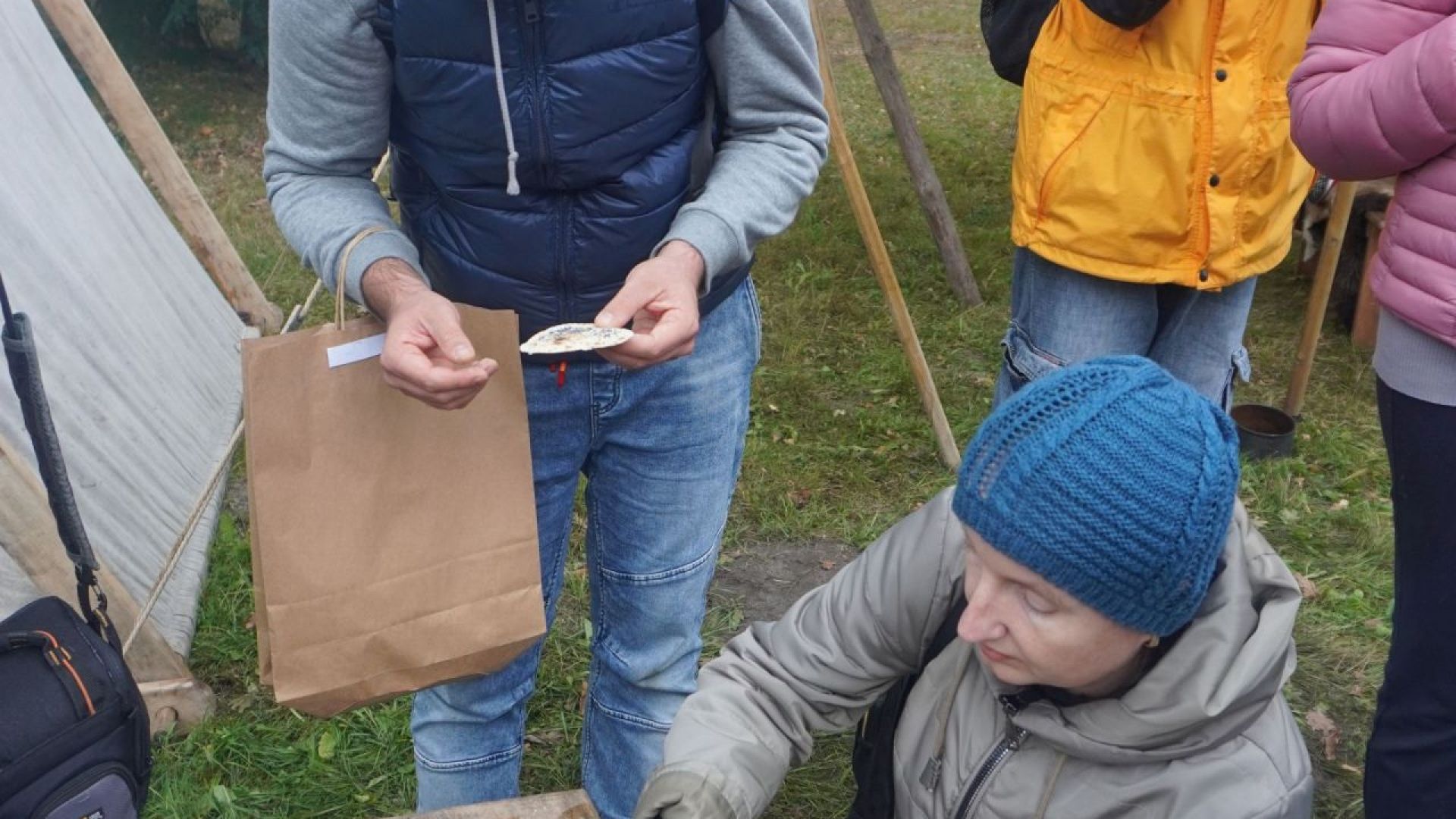 Uczestnicy jedzą podpłomyki podczas V Festynu Archeologicznego ''Kierunek Grodzisko!'' w Mrozach.