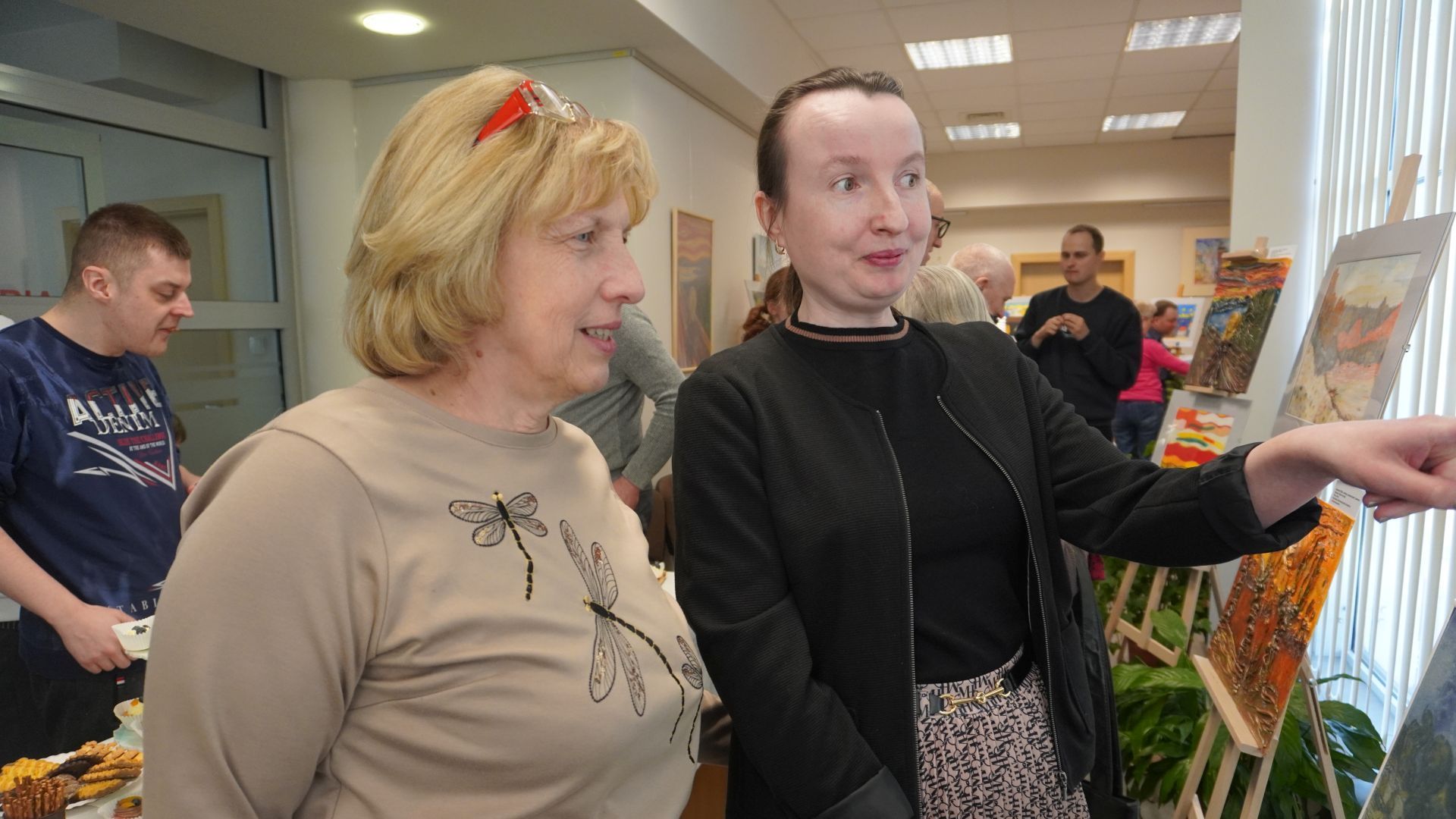 Anna Cz. wraz z mamą podziwia wykonane przez siebie prace podczas wernisażu ''Sztuka-moja pasja''. 