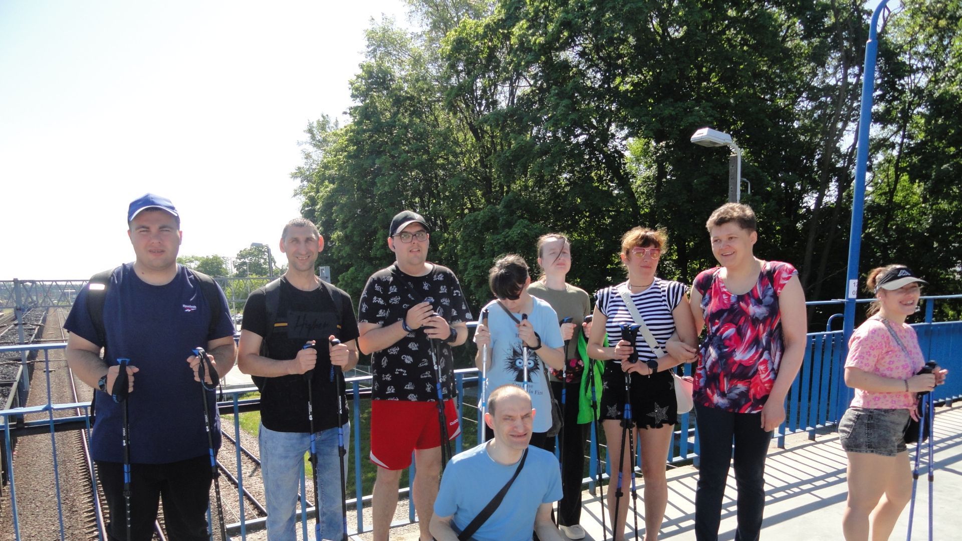 Uczestnicy podczas spaceru z kijkami do nordic walking zatrzymali się na kładce przy stacji PKP.