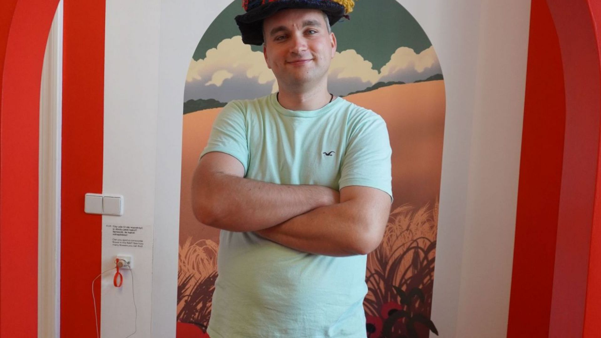 Uczestnik Konrad podczas wizyty w Muzeum Etnograficznym w Warszawie pozuje do zdjęcia w kapeluszu.