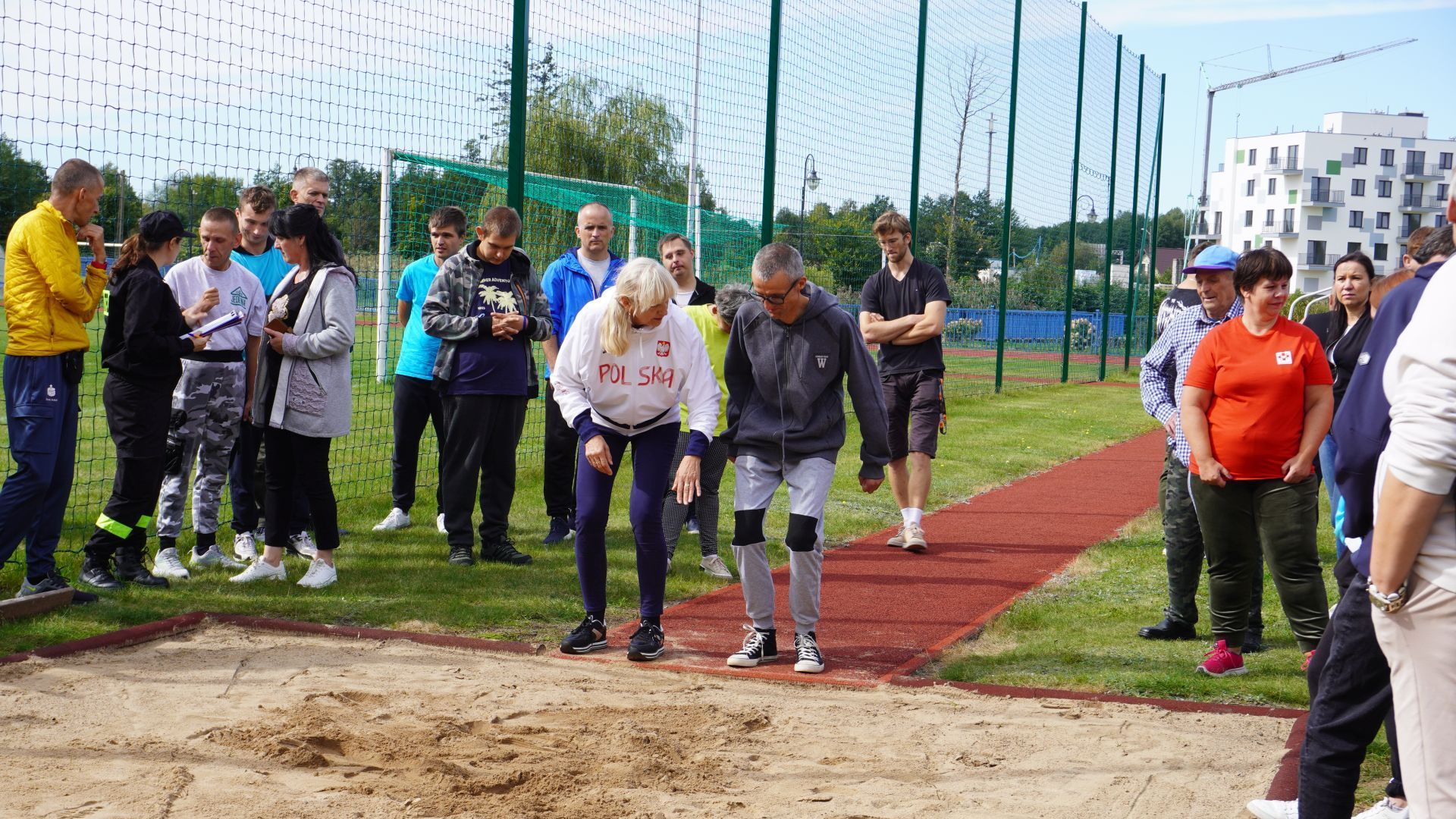 Uczestnik Grzegorz przygotowuje się do skoku w dal z pomocą olimpijki Urszuli Kielan podczas integracyjnej olimpiady sportowej ''Mrozy bez Barier''. 