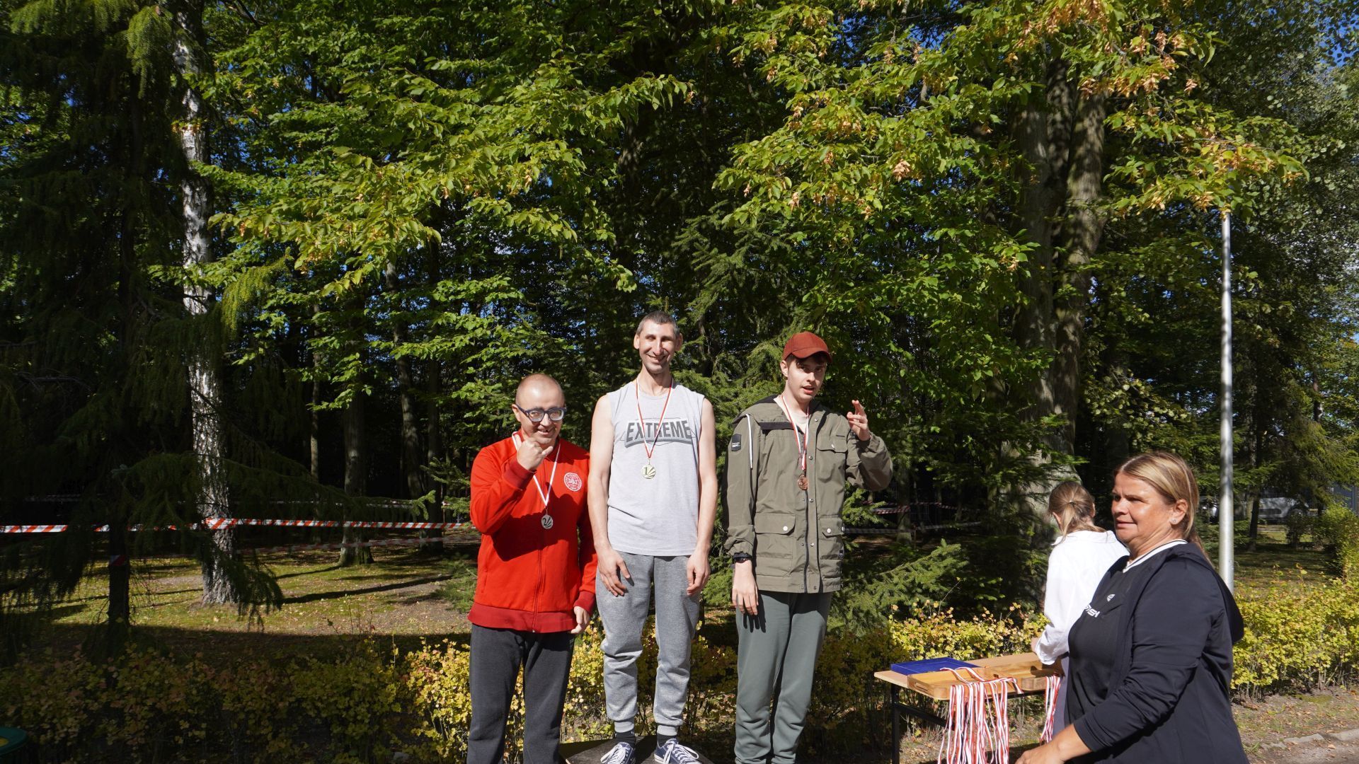 Uczestnik Sebastian stoi na podium za zajęcie I miejsca w biegu podczas zawodów sportowych w Zespole Szkół Specjalnych w Ignacowie.