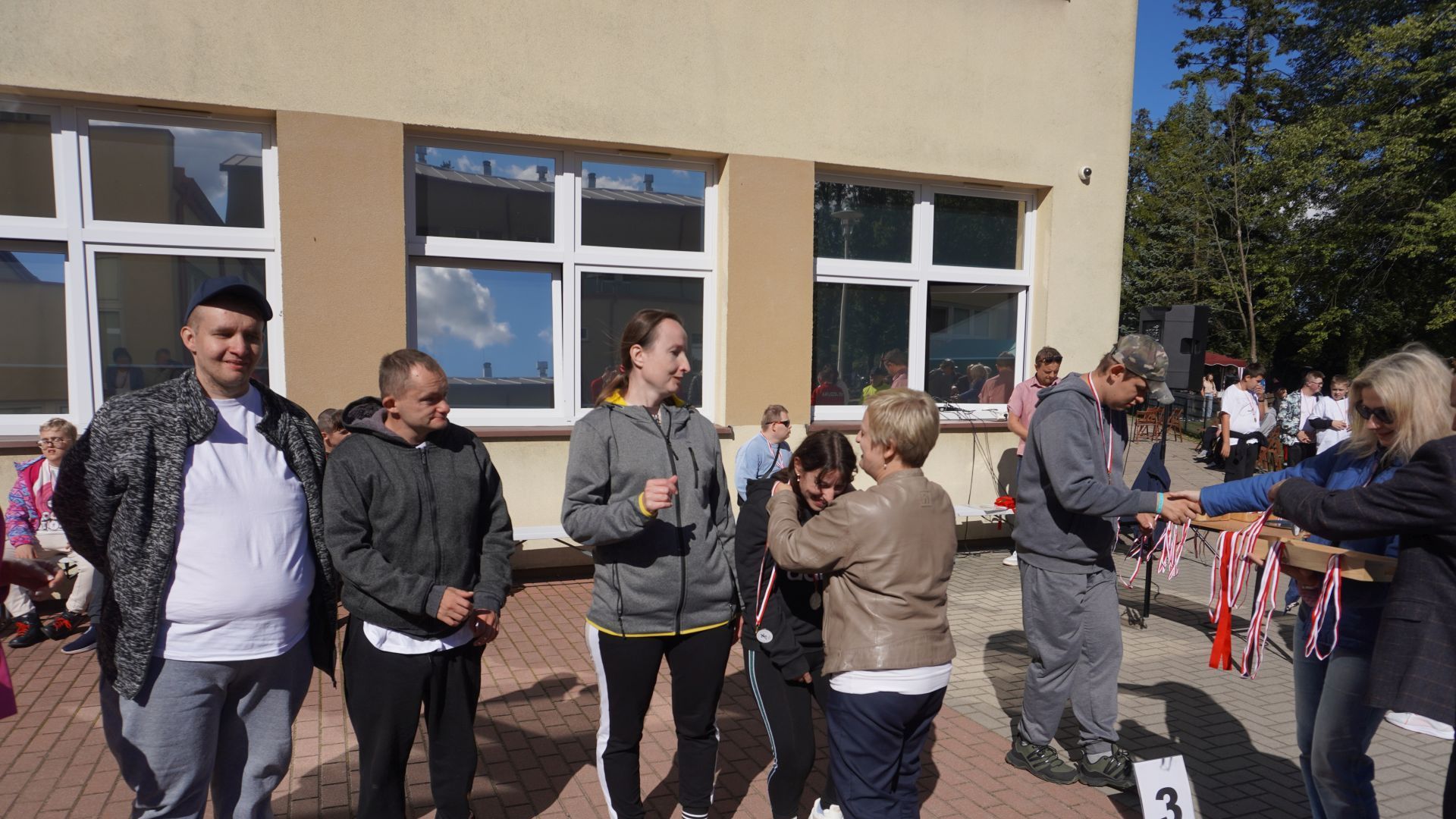 Pani dyrektor Justyna Juszczak zakłada medal uczestniczce Justynie K. za zajęcie II miejsca w piłkarzyki podczas zawodów sportowych w Zespole Szkół Specjalnych w Ignacowie.