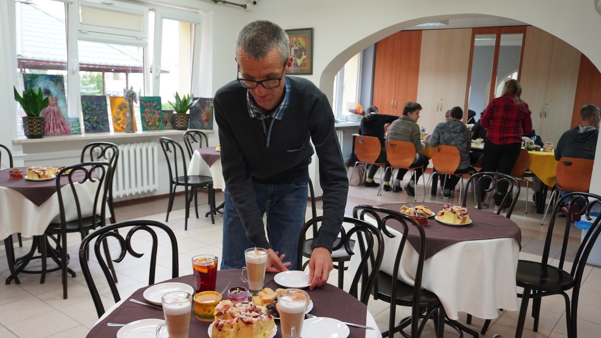 Uczestnik Grzegorz podaje kawę do stolika w Art.-kawiarni podczas warsztatów ''W świecie wosku i zapachów'' z uczniami z Zespołu Szkół Zawodowych nr 2 w Mińsku Mazowieckim. 