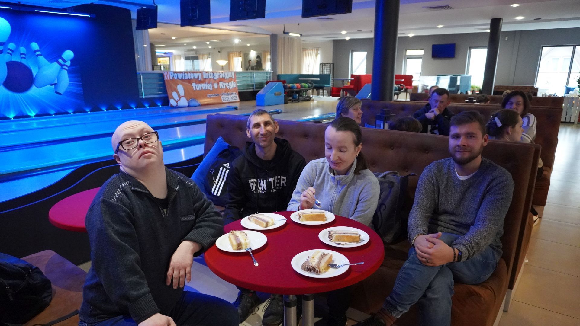 Uczestnicy PŚDS jedzą tort podczas XV Powiatowego Integracyjnego Turnieju w Kręgle.