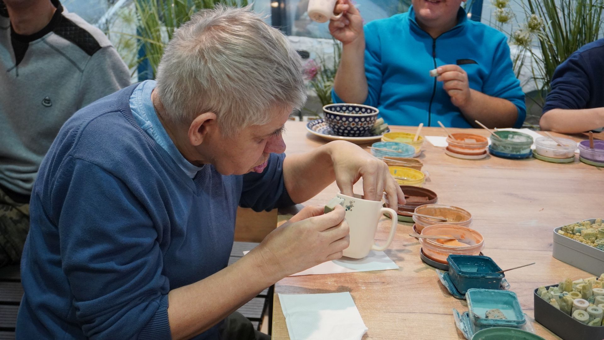 Uczestnik naszego Domu Sławomir ozdabia gliniany kubek podczas Warsztatów Ceramiki Bolesławiec w Lublinie.