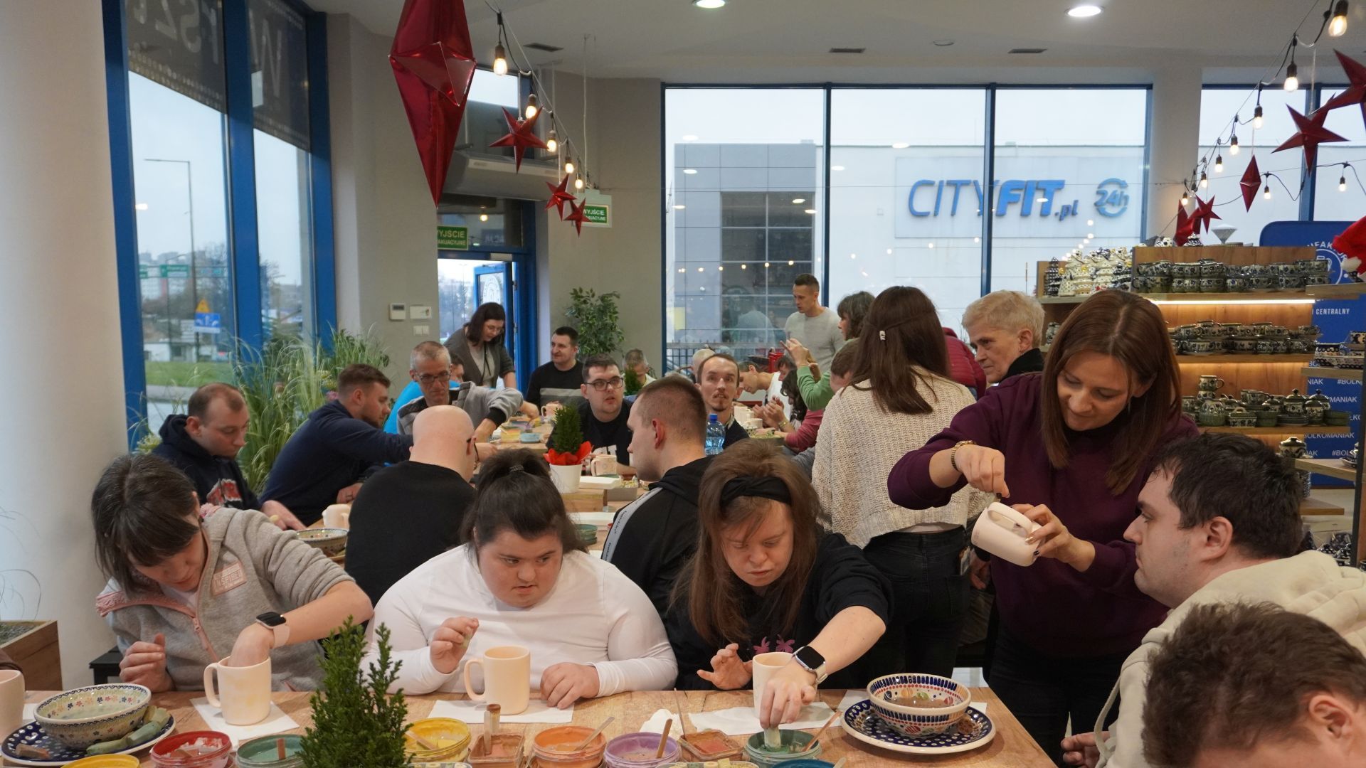 Uczestnicy naszego Domu wraz z terapeutą ozdabiają gliniane kubki podczas Warsztatów Ceramiki Bolesławiec w Lublinie.