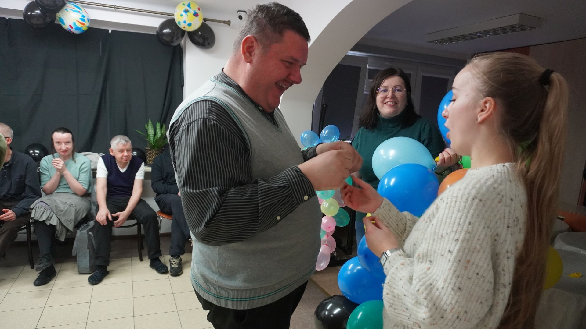 Uczestnik naszego Domu Damian T.  pokazuje terapeucie karteczkę z wróżbą podczas imprezy andrzejkowej.