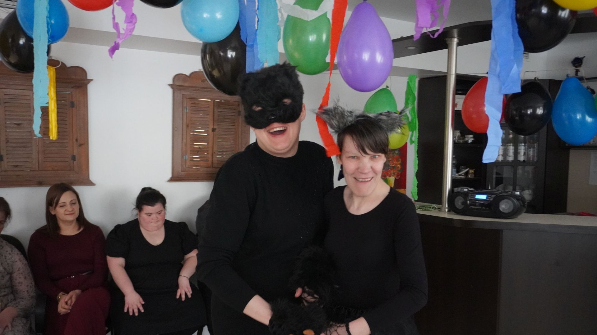 Uczestniczki Aneta i Małgosia przebrane za koty tańczą razem podczas balu karnawałowego.