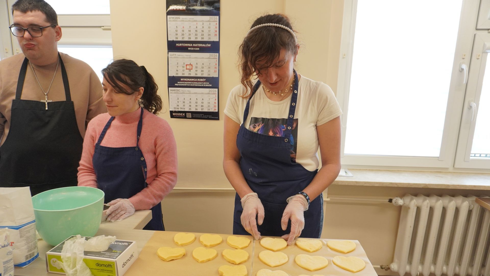 Uczestnicy w pracowni kulinarnej przygotowują pączki na Tłusty Czwartek.