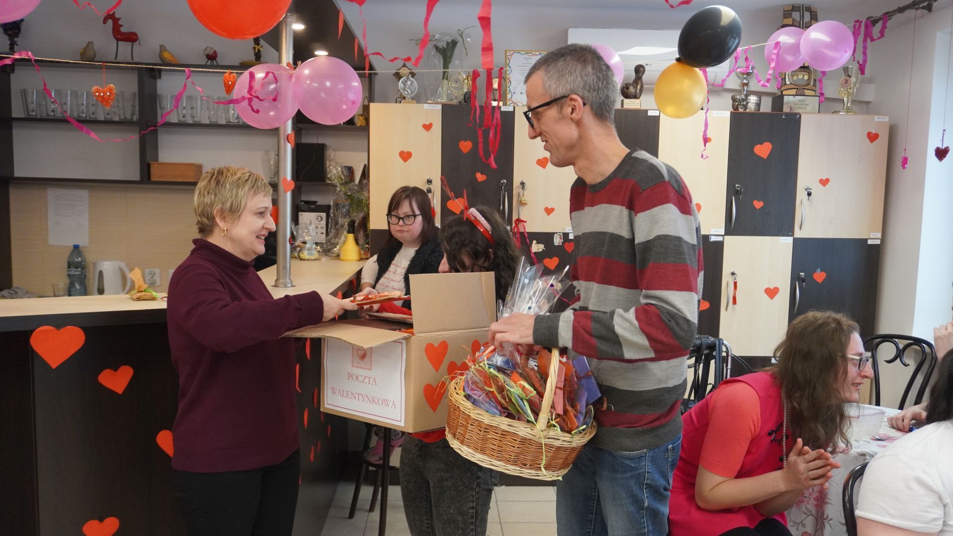 Przedstawiciele Rady Domu Justyna K. i Grzegorz wraz z panią dyrektor Justyną Juszczak rozdają pocztę walentynkową.
