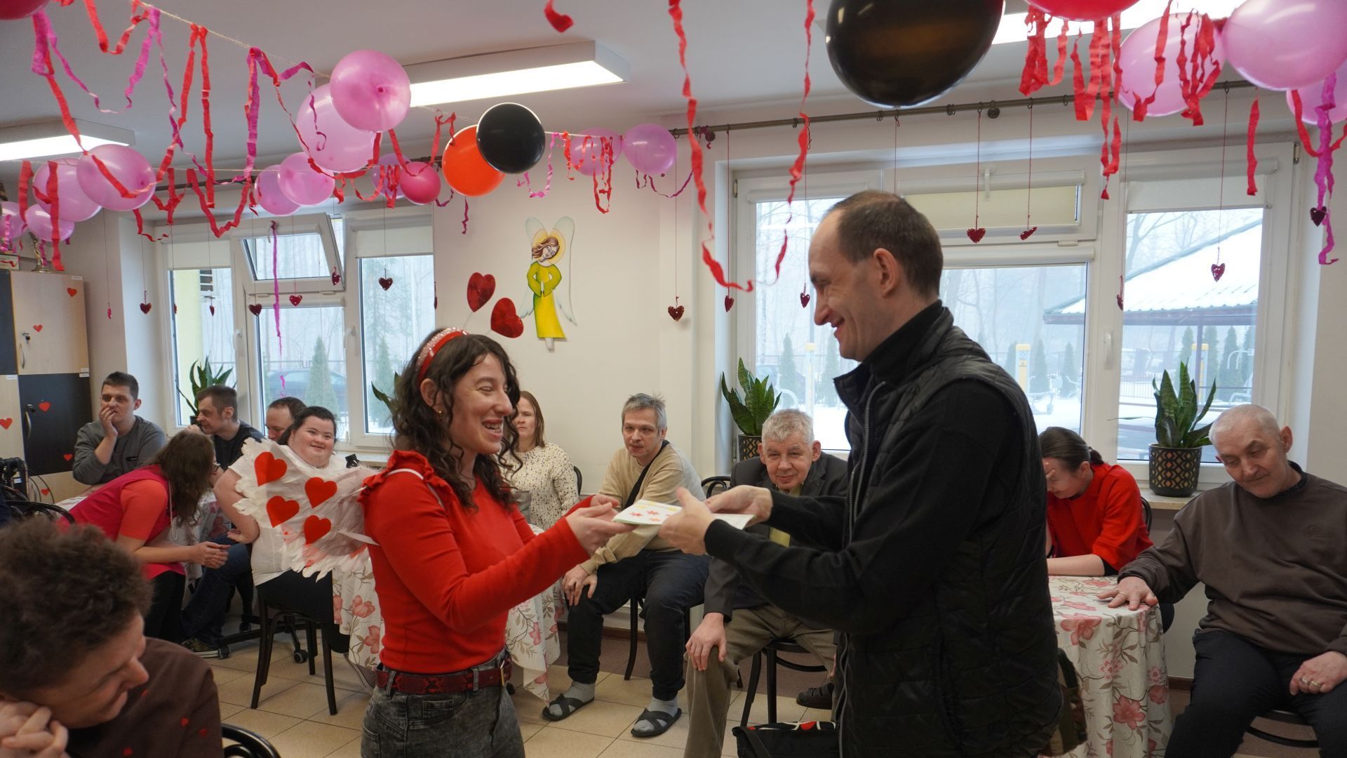 Przewodnicząca Rady Domu wręcza kartki walentynkowe uczestnikowi Pawłowi W.