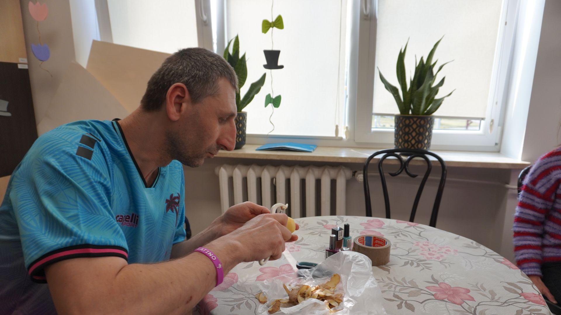 Uczestnik Sebastian obiera ziemniaka podczas zajęć integracyjnych z okazji Dnia Kobiet i Mężczyzn. 