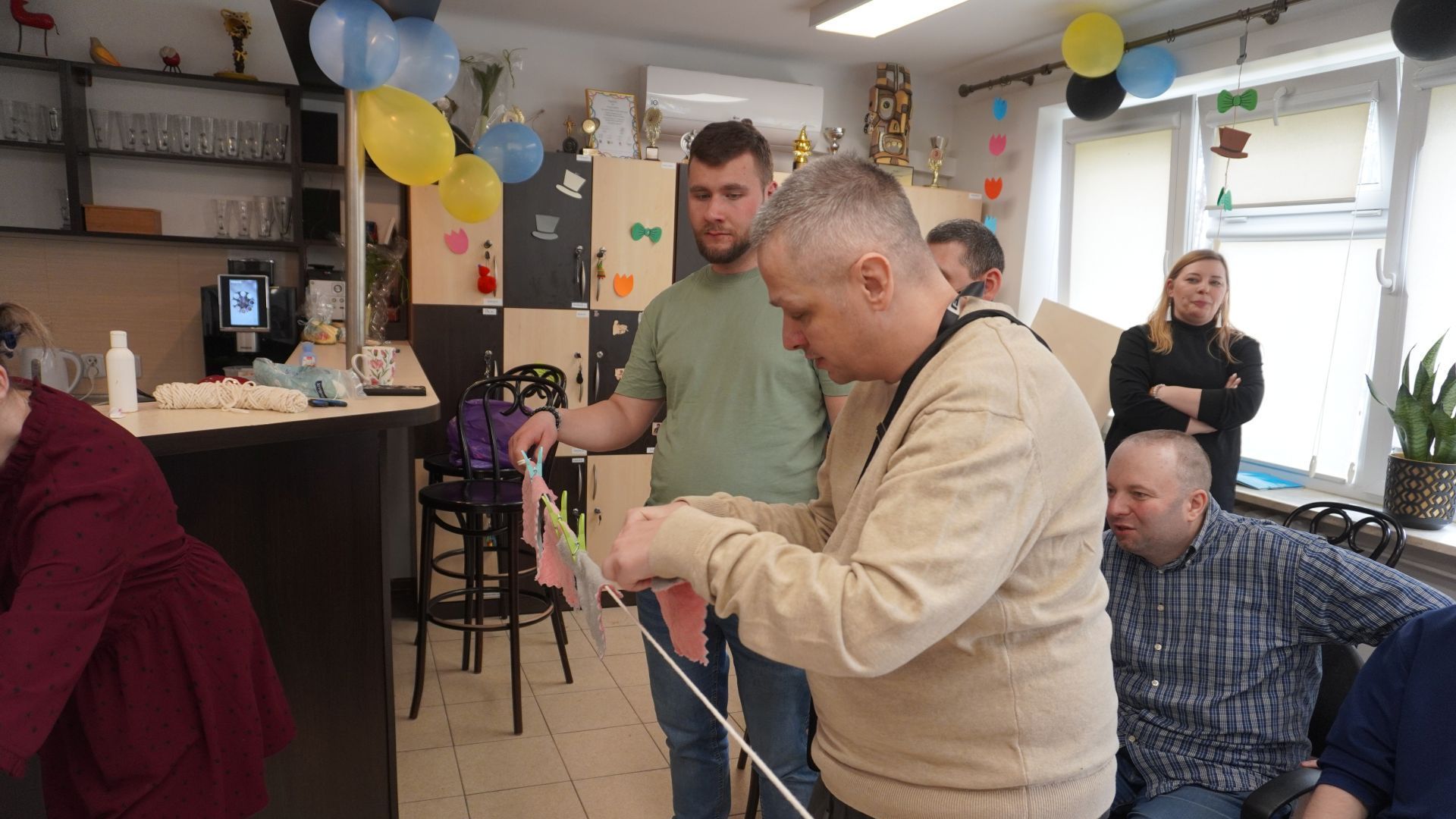 Uczestnicy Michał S. i Bartłomiej rozwieszają pranie podczas zajęć integracyjnych z okazji Dnia Kobiet i Mężczyzn. 