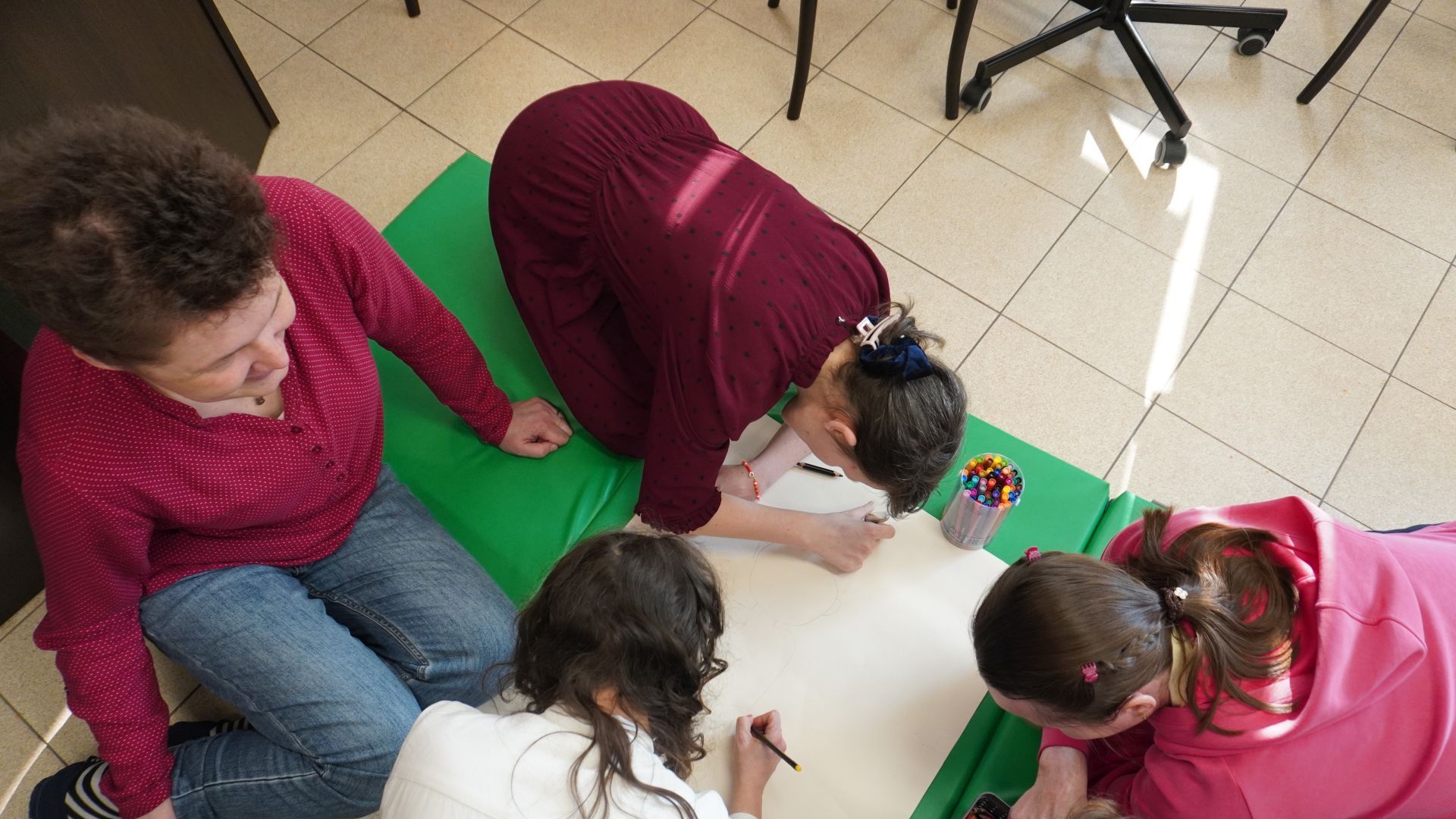 Uczestniczki PŚDS wykonują wspólną pracę plastyczną podczas zajęć integracyjnych z okazji Dnia Kobiet i Mężczyzn.