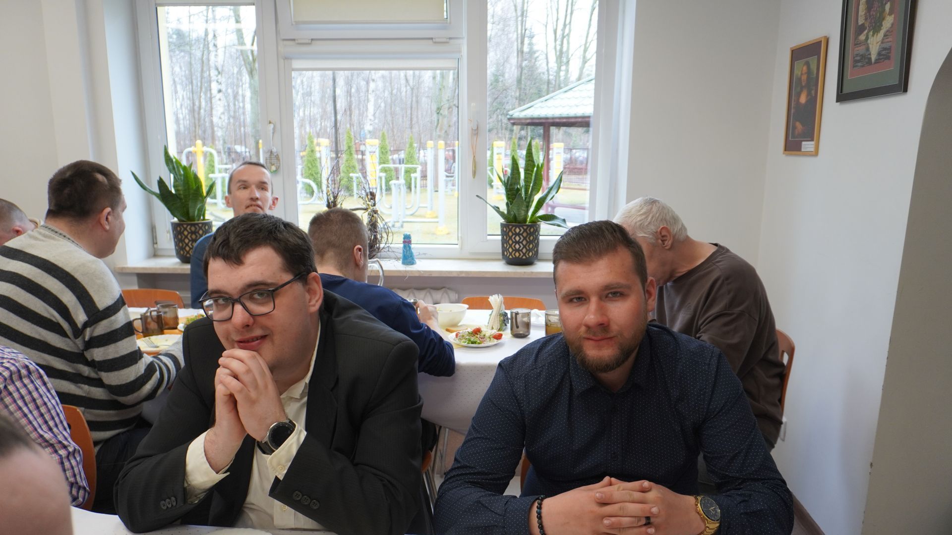 Uczestnicy, Karol i Bartek siedzą przy stole podczas spotkania wielkanocnego.