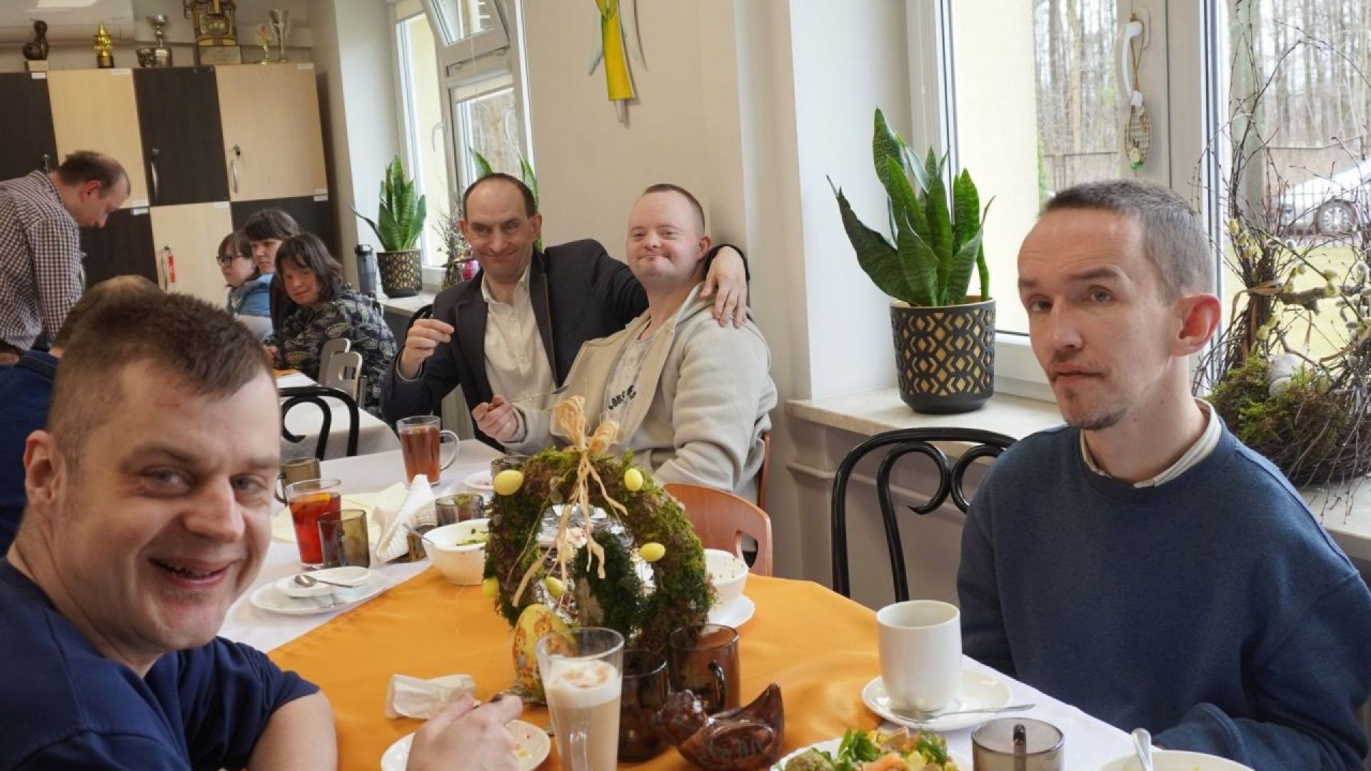 Uczestnicy siedzą przy stole podczas spotkania wielkanocnego.