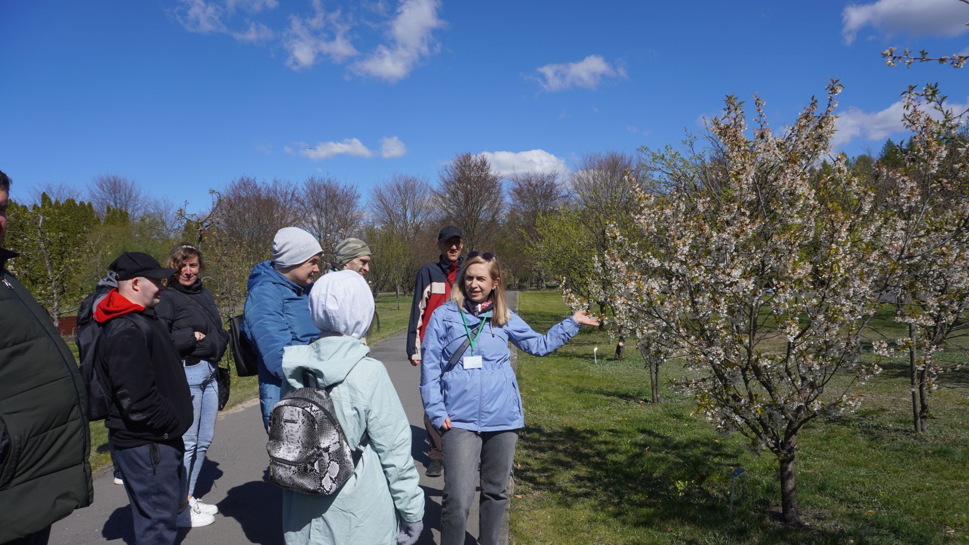 Uczestnicy słuchają pani przewodnik podczas wycieczki do Ogrodu Botanicznego w Powsinie.