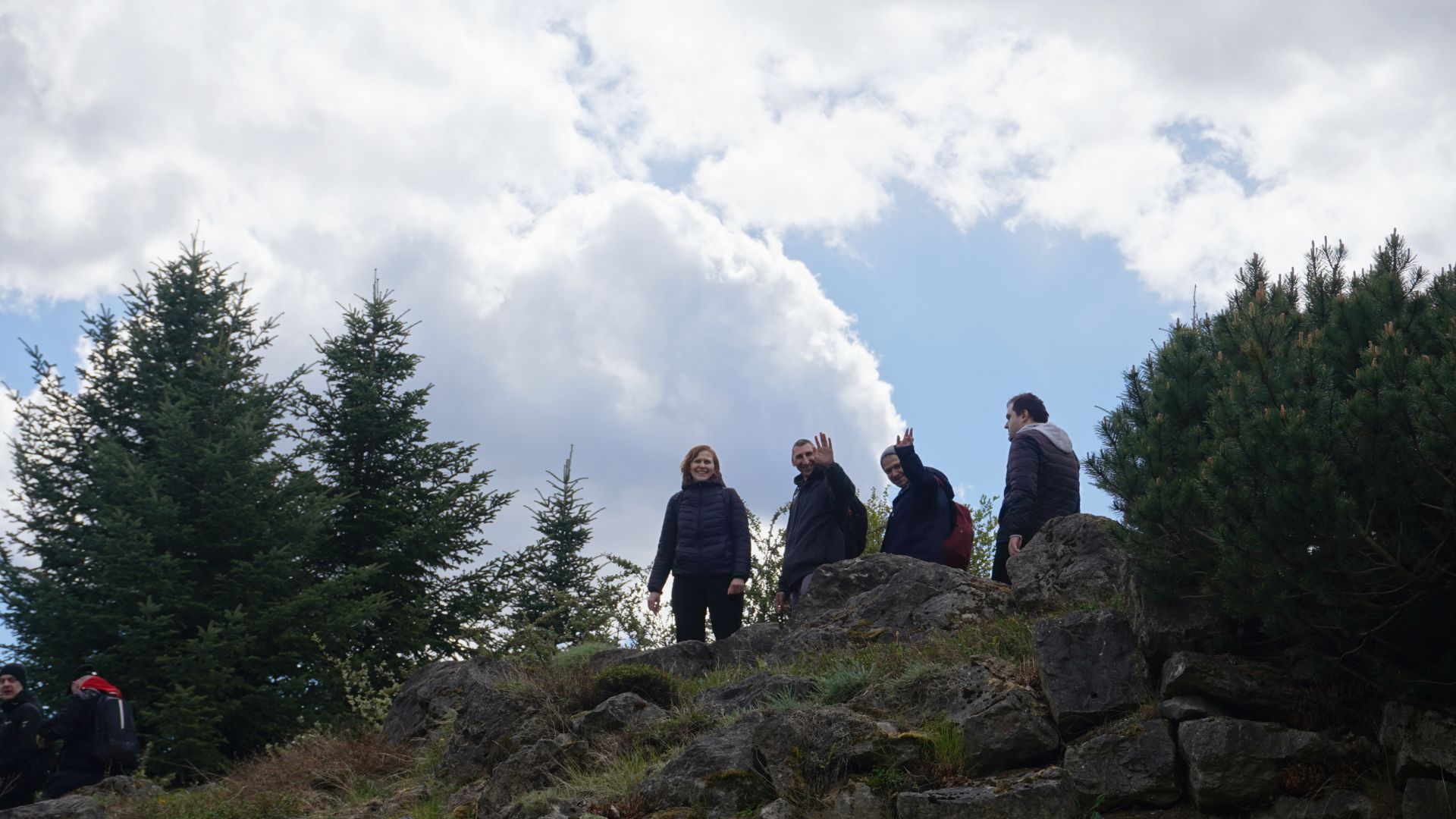 Uczestnicy machają kolegą po wspięciu się na górkę w Ogrodzie Botanicznym w Powsinie. 