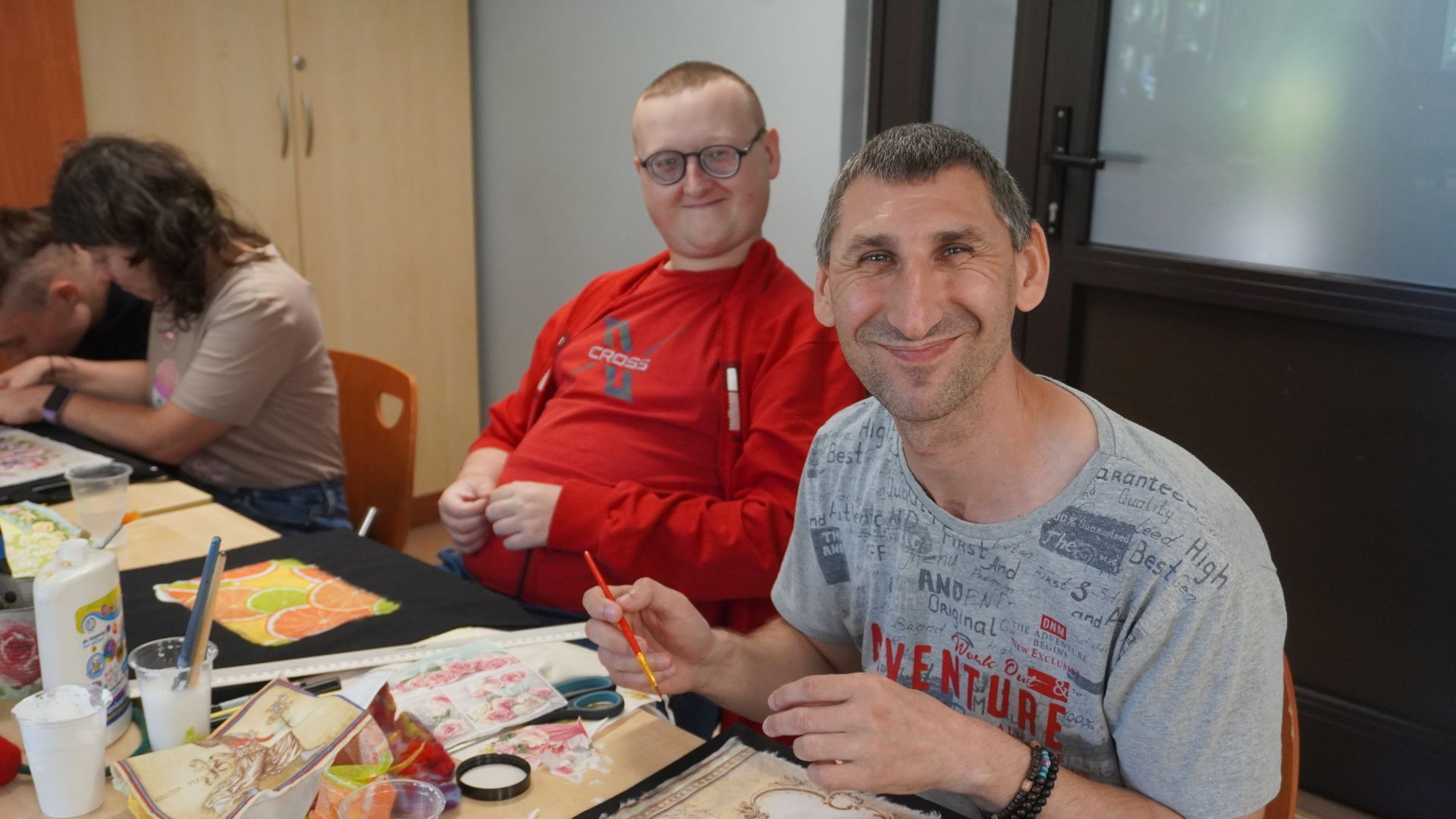 Uczestnicy warsztatów ozdabiania toreb płóciennych ''Jesteśmy dla innych'' wykonują swoje torby.