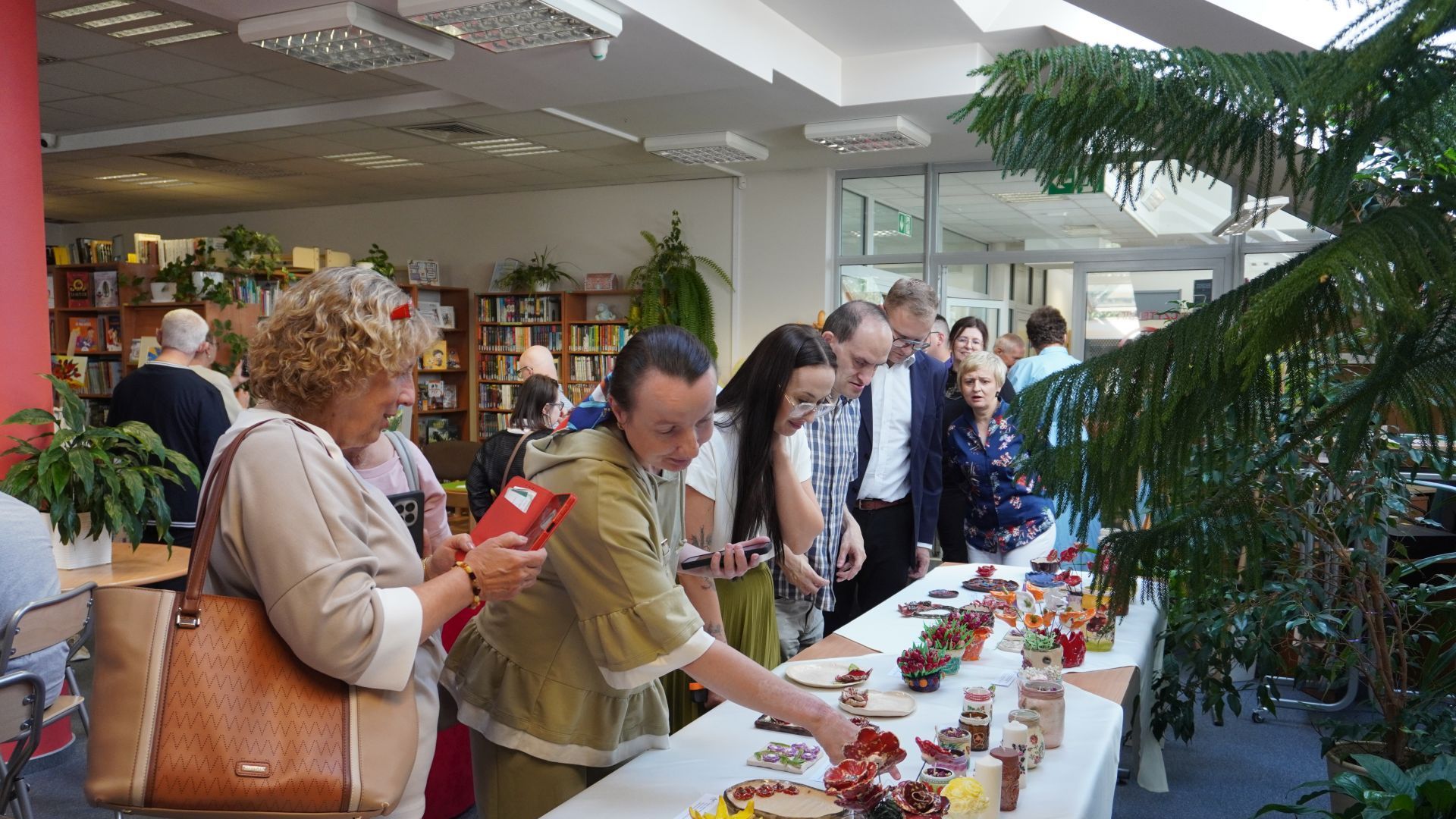 Zaproszeni goście oglądają prace uczestników PŚDS  podczas wernisażu wystawy ''Kwiaty polskie'' w Bibliotece Pedagogicznej w Mińsku Mazowieckim.
