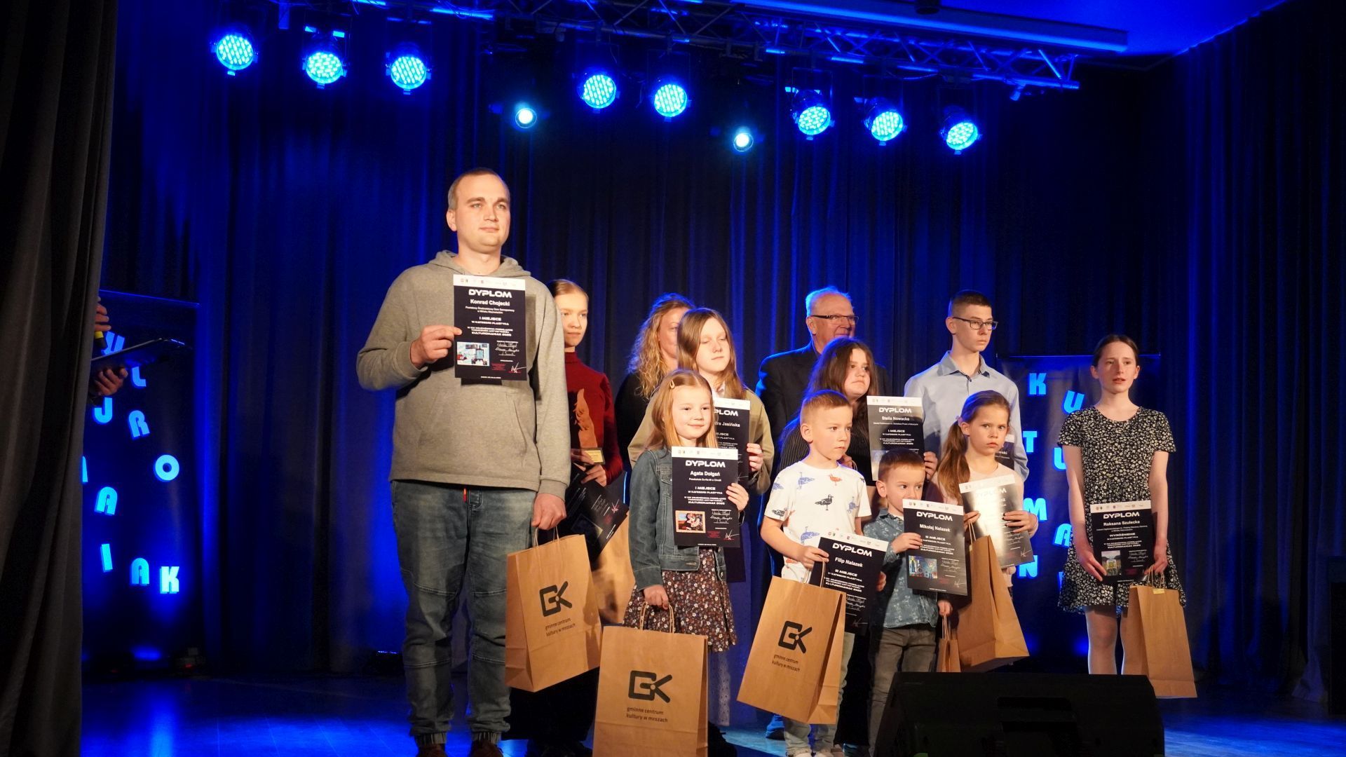 Konrad Ch. stoi na scenie wraz z innymi laureatami XIX WOJEWÓDZKIEGO PRZEGLĄDU TWÓRCZOŚCI ARTYSTYCZNEJ - KULTUROMANIAK
