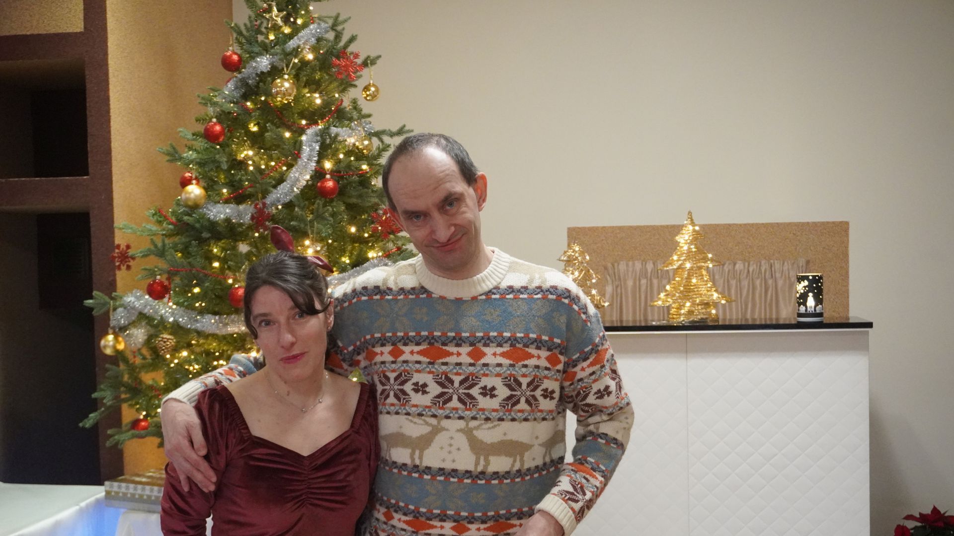 Uczestnicy naszego Domu Justyna K. i Paweł W. stoją przy choince podczas spotkania opłatkowego 2025.